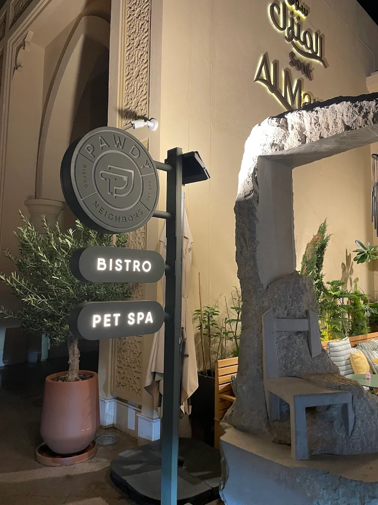 Outdoor signage for Pawdy Neighbors Bistro and Pet Spa at Al Manzil.