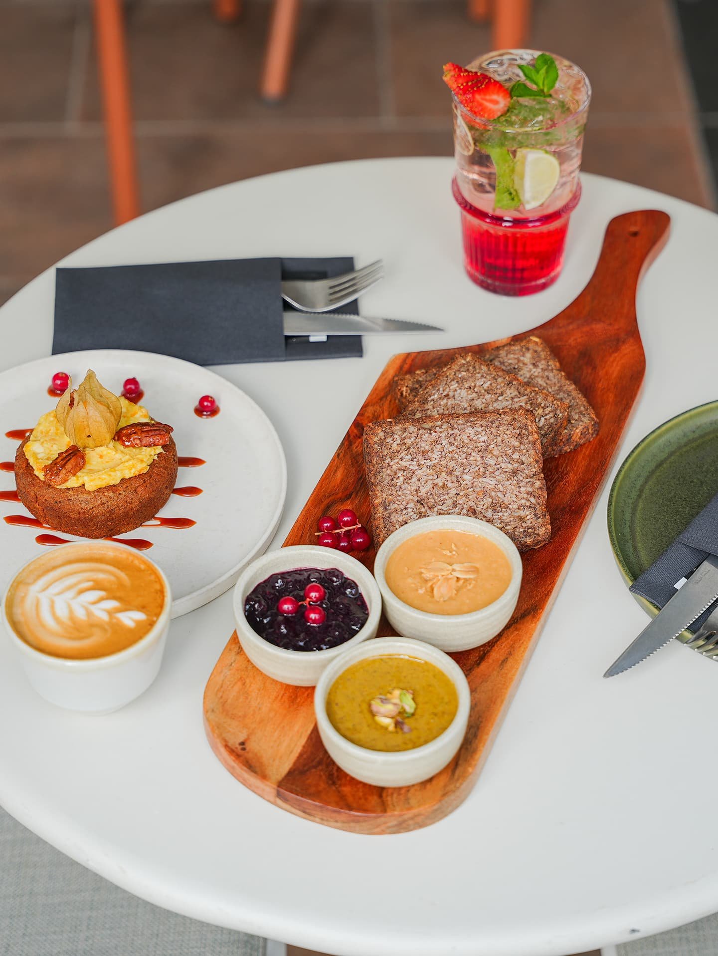 Dark grey puppy peeking through a torn paper hole.